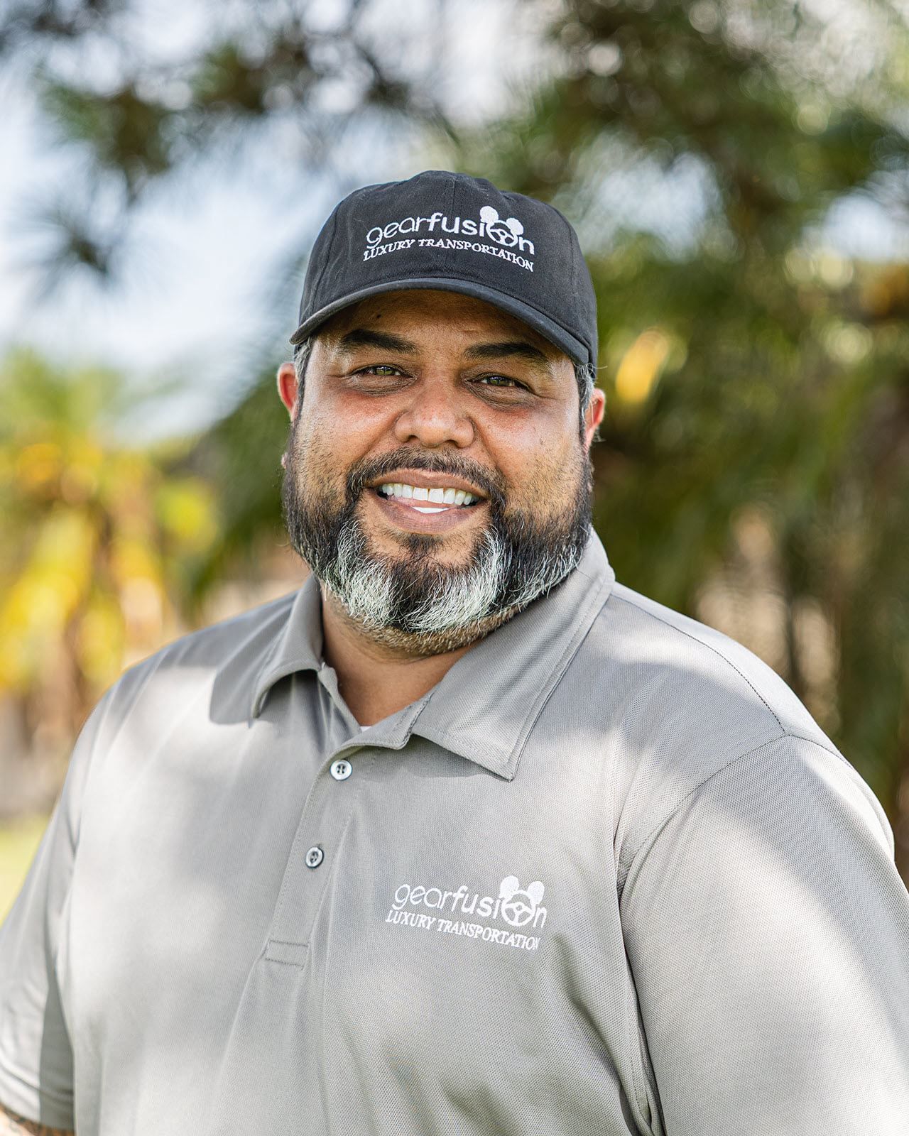 A man with a beard and a hat is smiling for the camera.