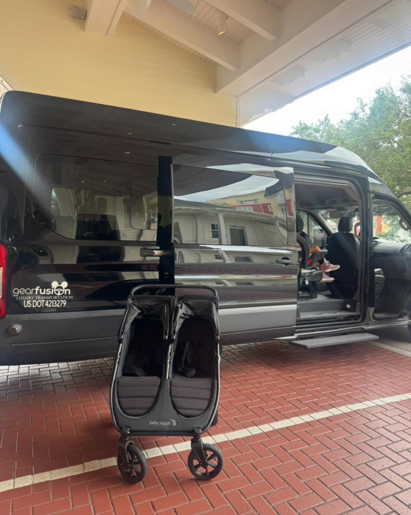 A black ford expedition is parked in front of a palm tree.