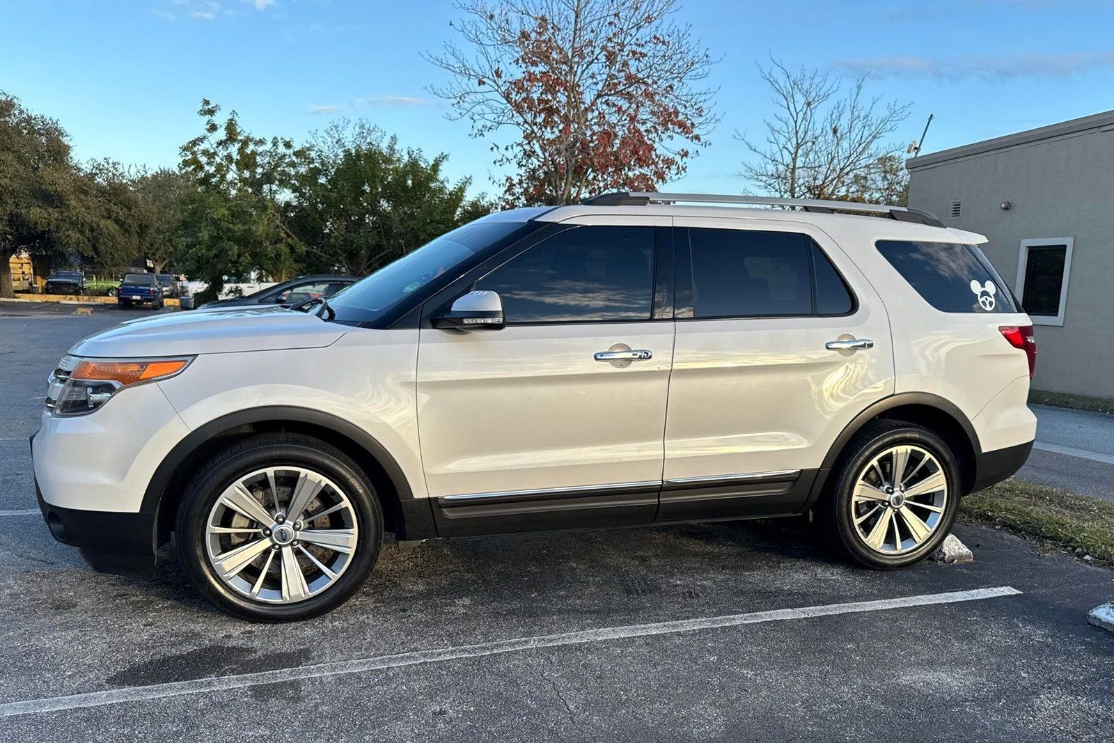 A white ford explorer is parked in a parking lot.