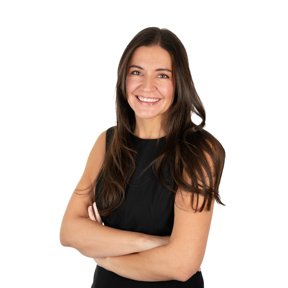 Woman with long, brown hair smiling, arms crossed, wearing a black sleeveless top.