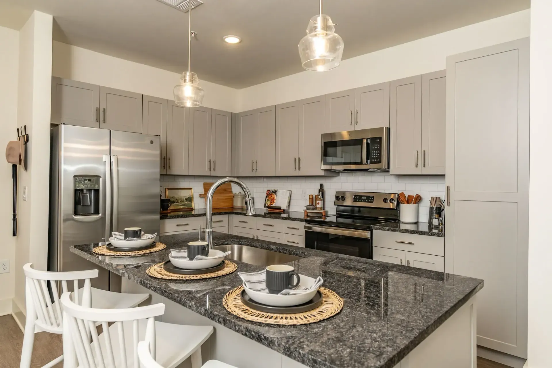 Modern kitchen with a granite countertop island at Livano Trinity.