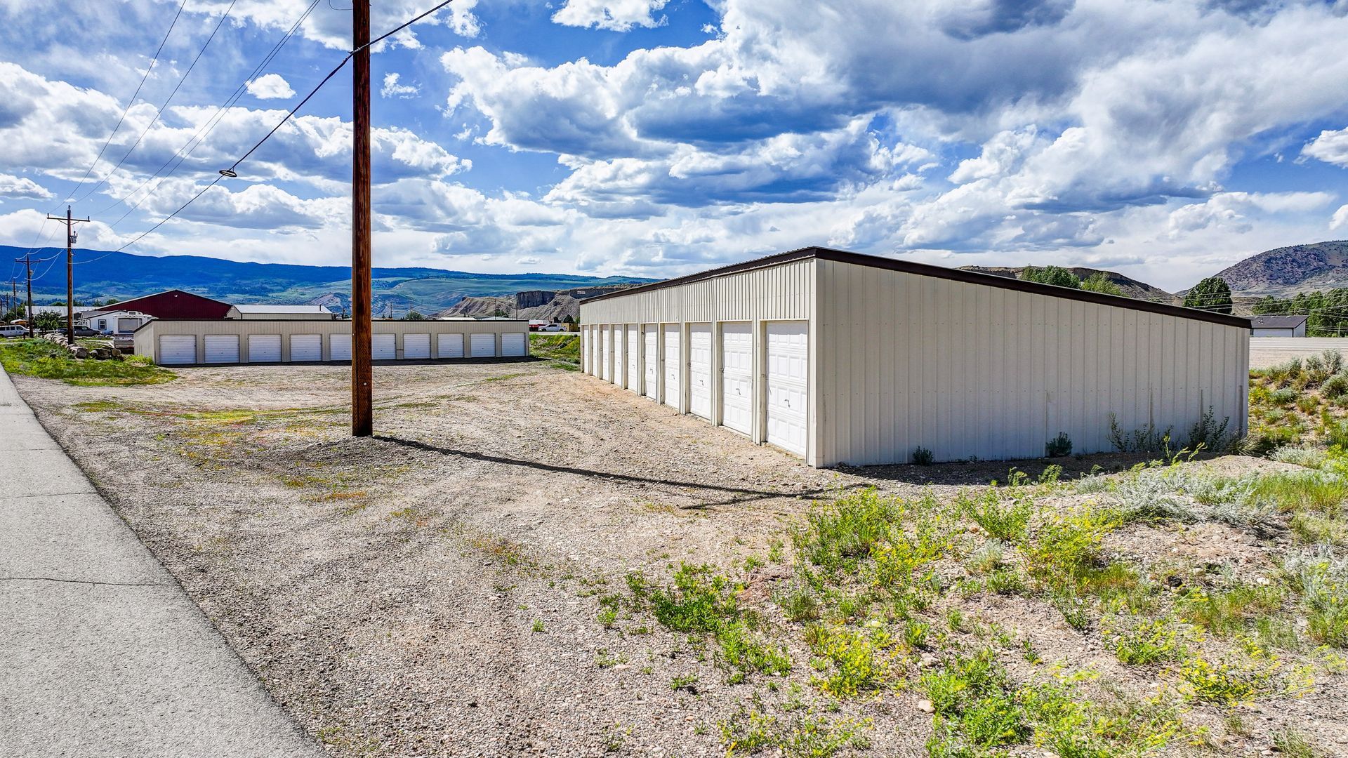 Storage units nestled among trees in a green, mountainous setting.
