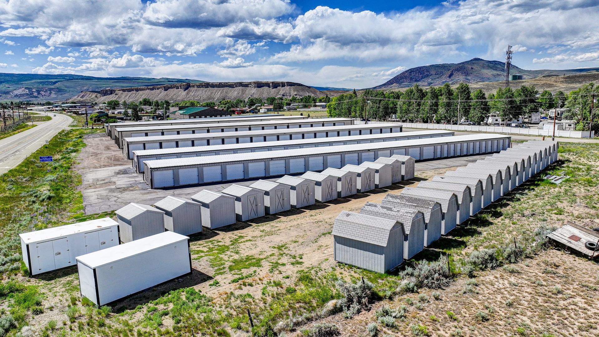 Storage units nestled among trees in a green, mountainous setting.