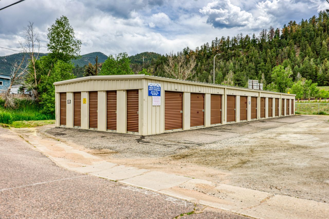 Photo of storage facility off side of road with mountains in the background. 