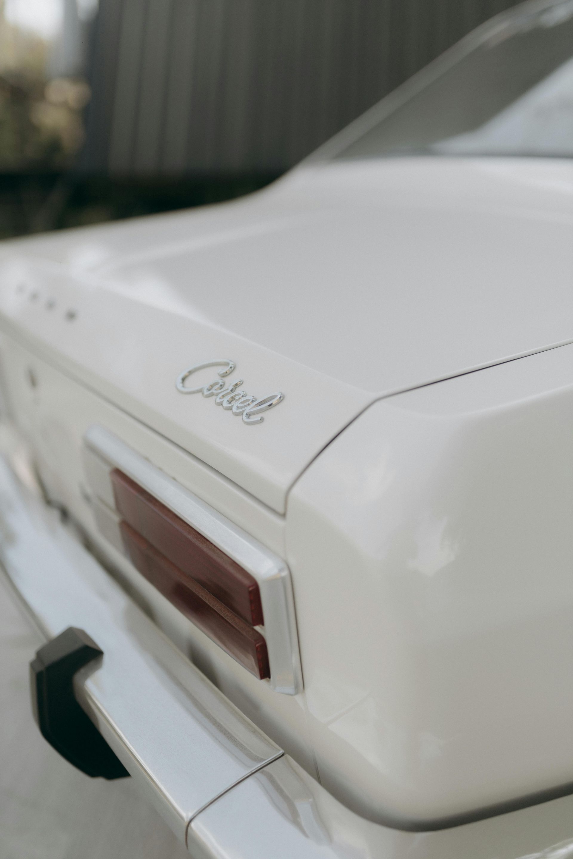 A white car with the word cobra on the trunk