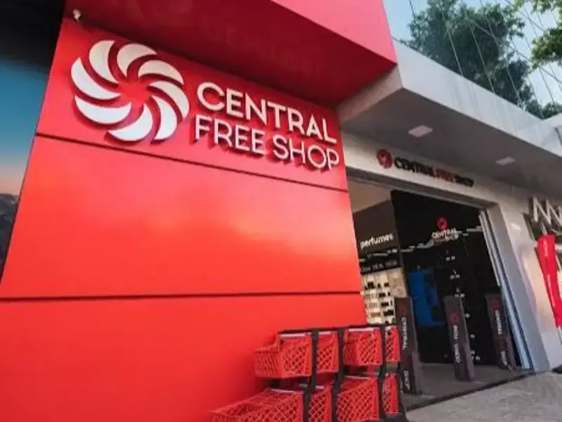 Exterior da Central Free Shop, fachada vermelha, logotipo com pétalas brancas em espiral e entrada visível.