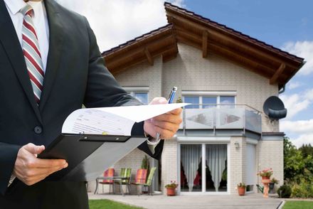 Man Checking Documents Standing Near House — St. Johns, FL — St. Johns Appraisals LLC