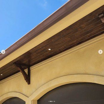 A building with a wooden ceiling and a blue sky in the background