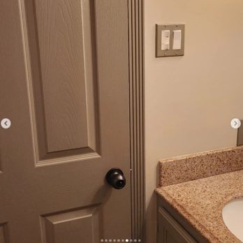 A bathroom with a sink and a light switch on the wall