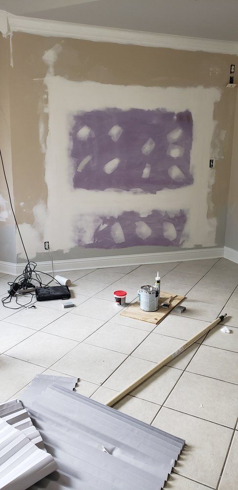 A room that is being remodeled with tile floors and a purple wall.