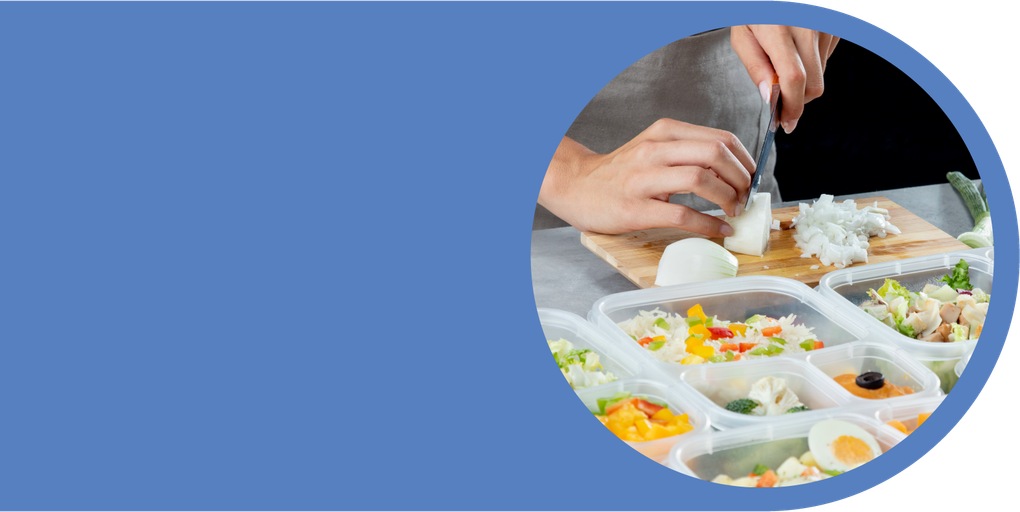 Volunteer preparing food trays for Bikur Cholim meal delivery program.