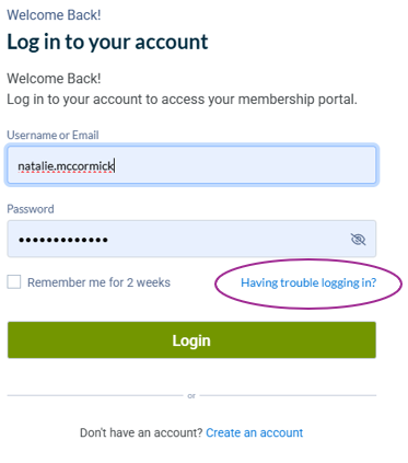 Conference hall with people at vendor booths, including a person speaking with a vendor at a 