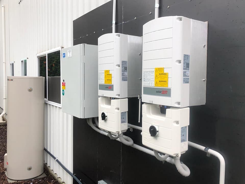 Three Solar Panels Are Mounted on the Side of a Building — Spot On Solar International in Beresfield, NSW