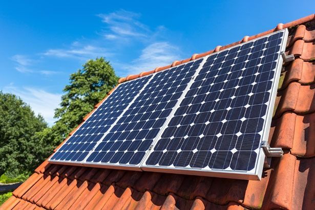A Row of Solar Panels Sitting on Top of a Tiled Roof — Spot On Solar International in Beresfield, NSW