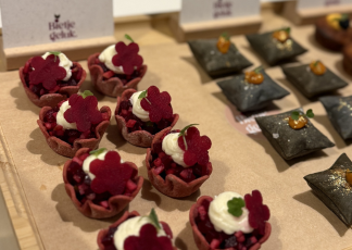 There is a bowl of salad on a wooden cutting board.
