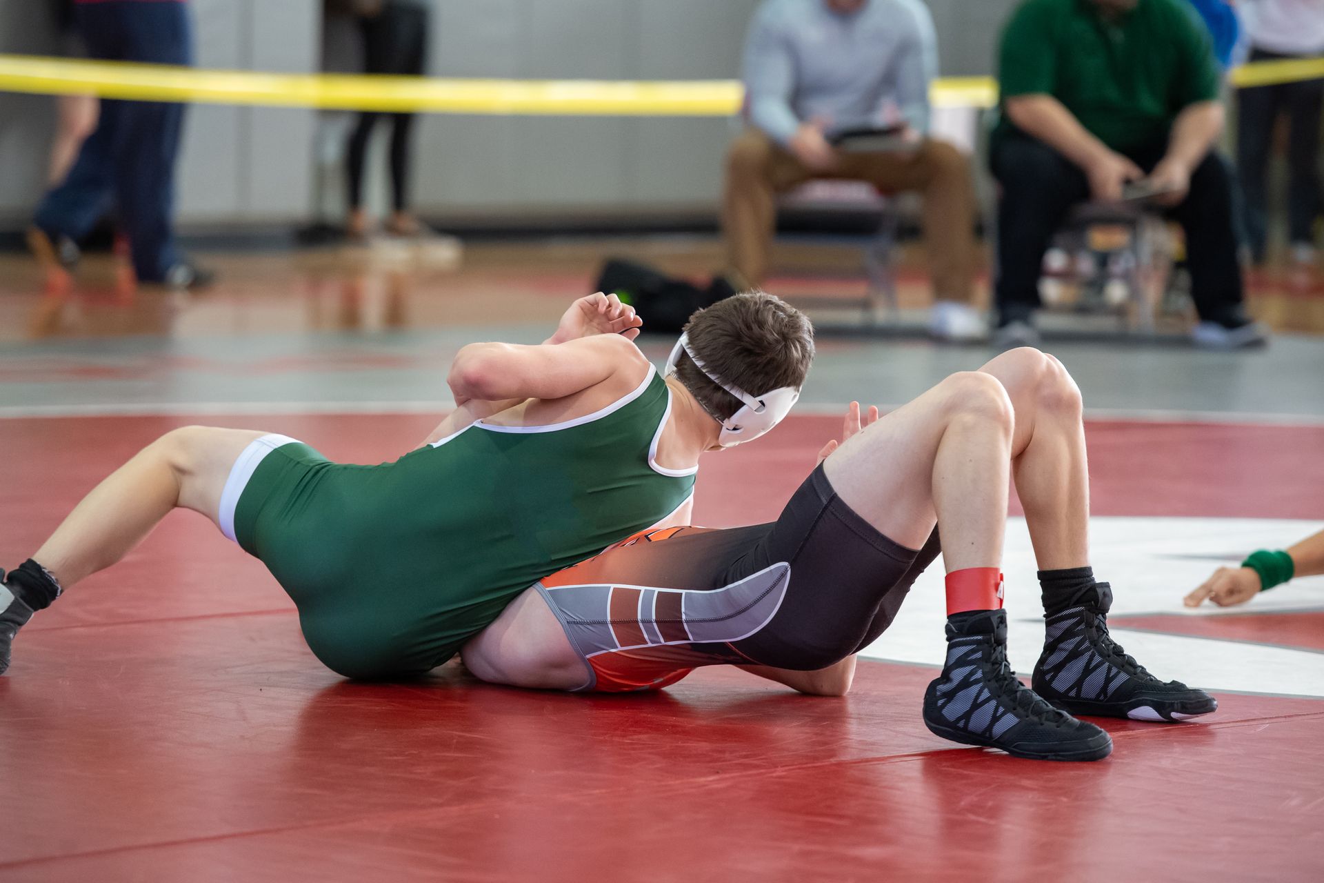 People playing pickleball on a blue court with a net, under a sunny sky near trees.