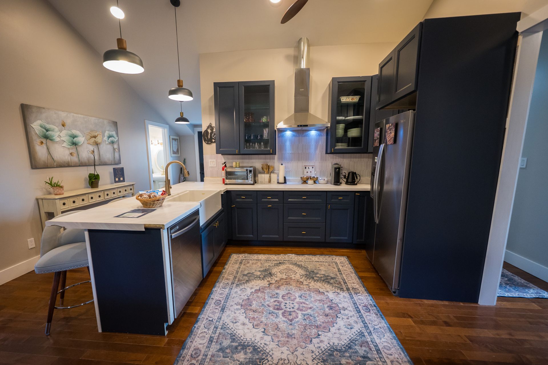 Kitchen with navy blue cabinets, white countertops, and stainless steel appliances.