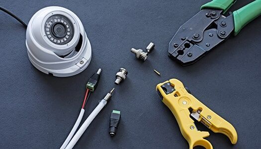 A Security Camera is Sitting on a Table next to a Pair of Pliers — Electronic Security in Tweed, NSW