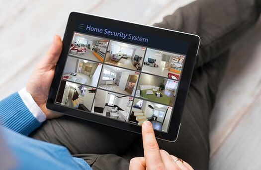 A Person is Holding a Tablet with a Home Security System on It — Electronic Security in Tweed, NSW