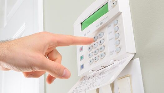 A Person is Pressing a Button on a Security System — Electronic Security in Tweed, NSW