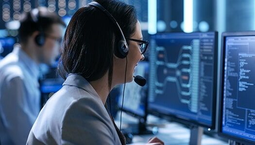 A Woman Wearing a Headset is Sitting in Front of a Computer — Electronic Security in Tweed, NSW