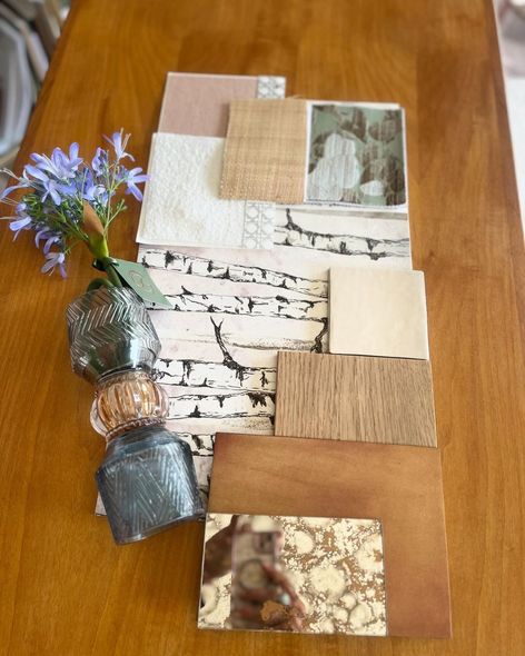 Un tavolo di legno con un vaso di fiori e un mucchio di carte sopra.