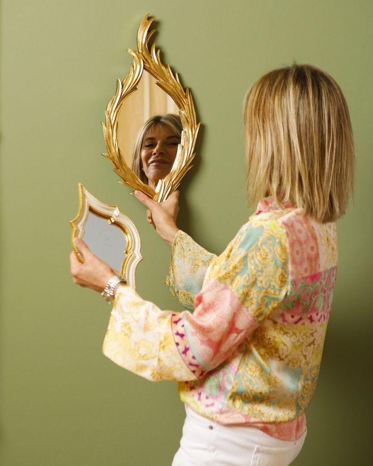 Una donna si guarda riflessa in uno specchio