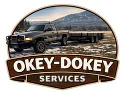 Gray pickup truck hauling a flatbed trailer in a field with a mountain backdrop. "Okey-Dokey Services" logo.