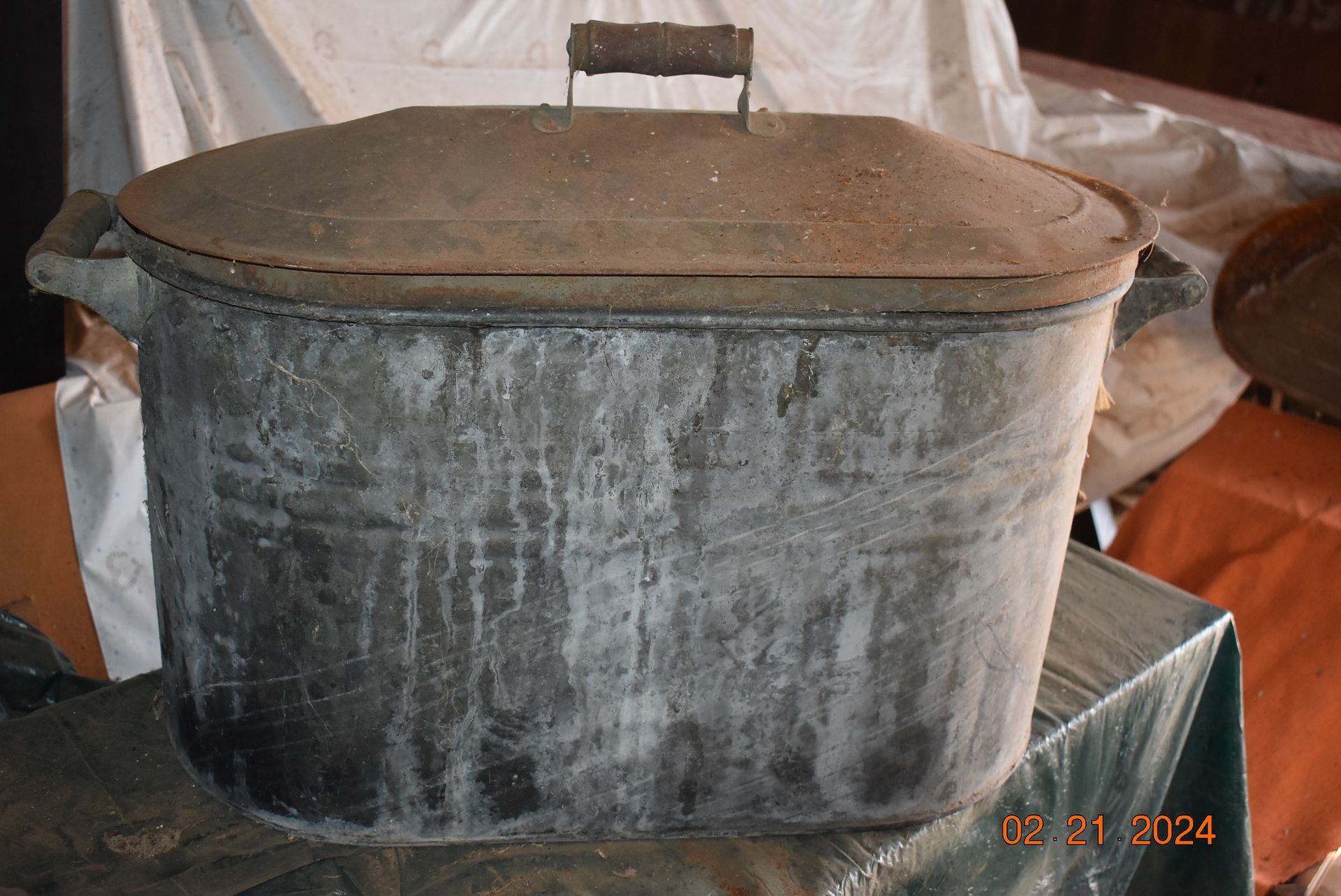 a large metal pot with a wooden handle is sitting on a table .