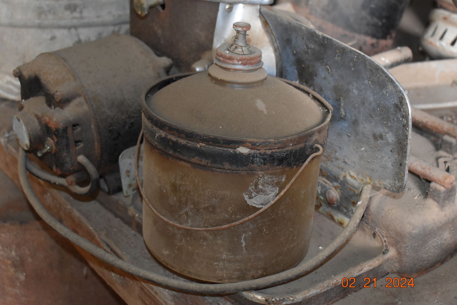 an old oil lamp with a handle is sitting on a table .
