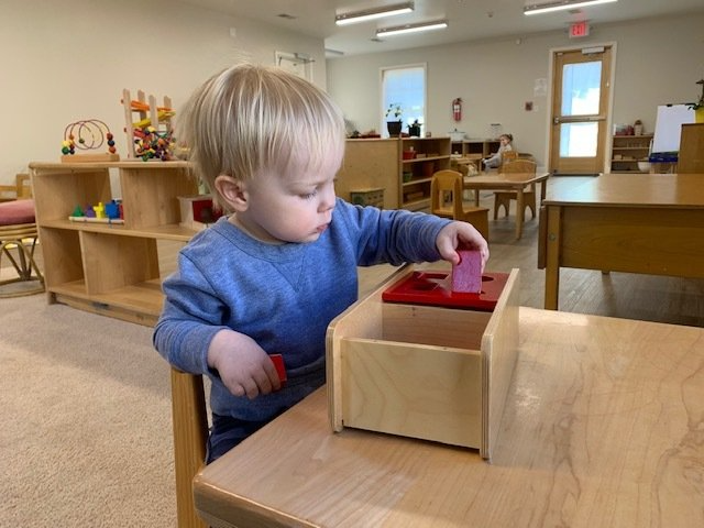 Montessori child working with a wooden shape sorter