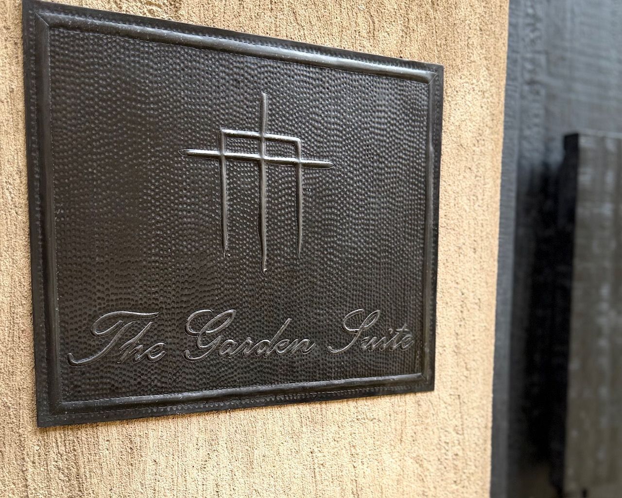 A sign on a wall that says the garden suite