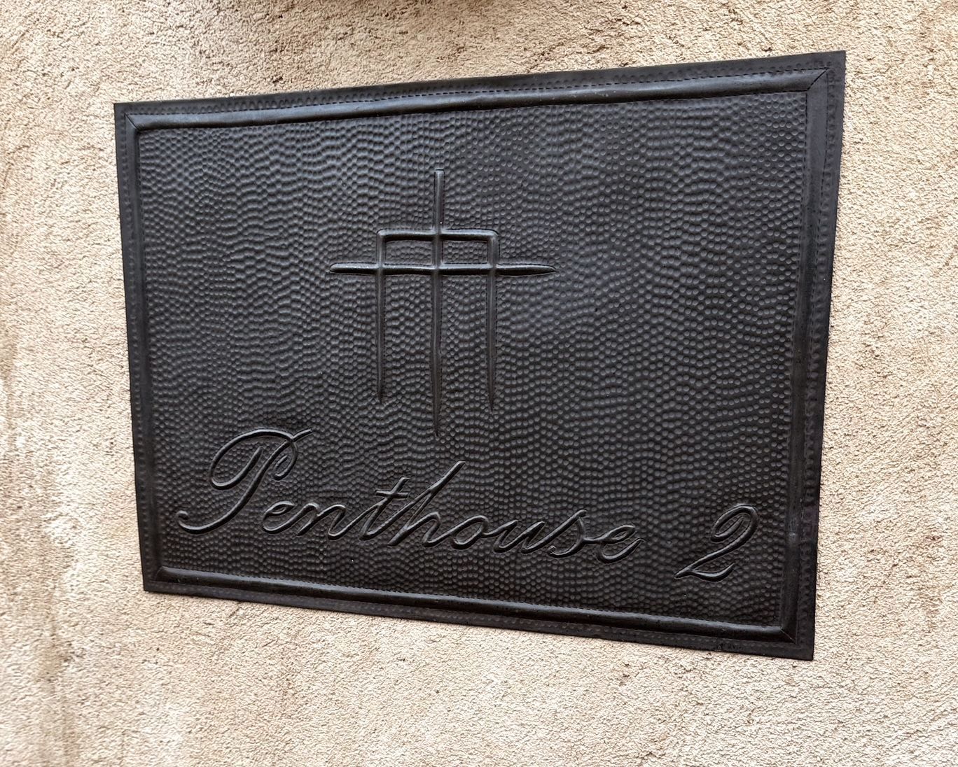 A black sign on a wall that says penthouse 2