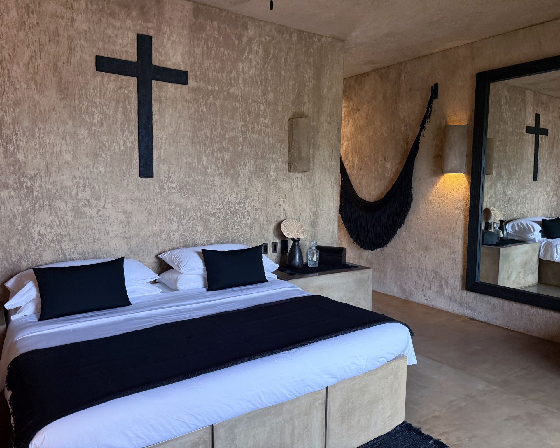 There are two crosses on the wall above the bed.