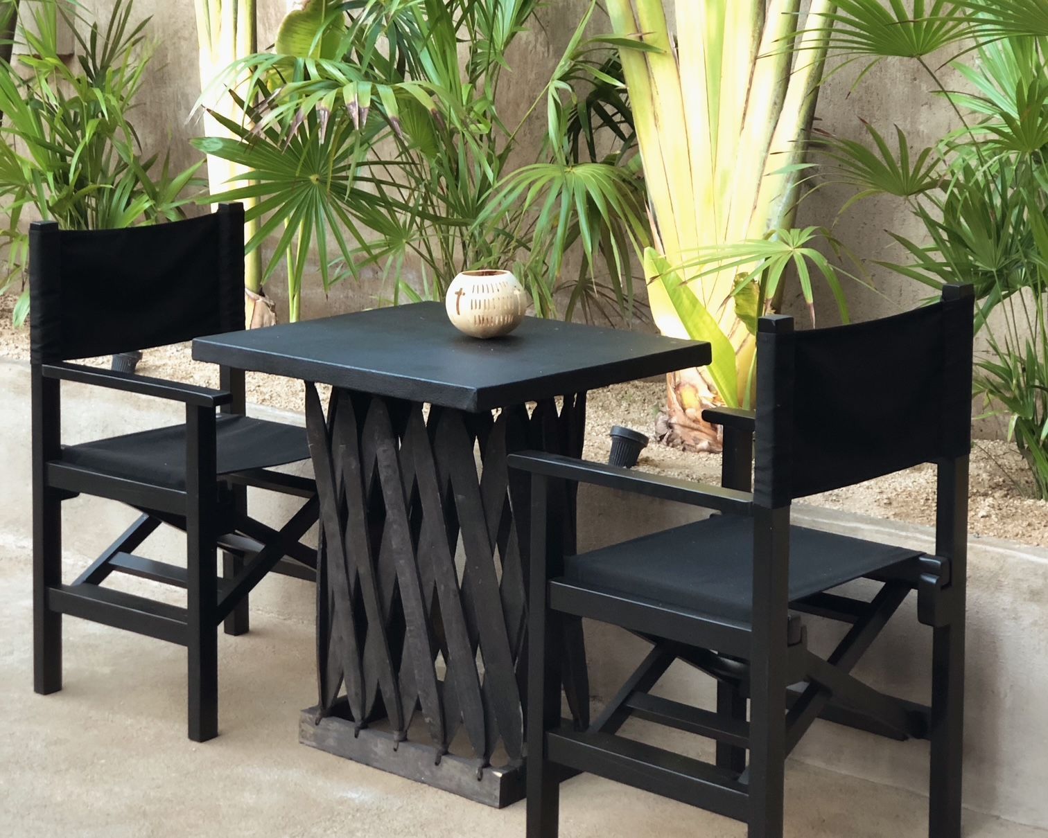 A table with two chairs and a plant on it