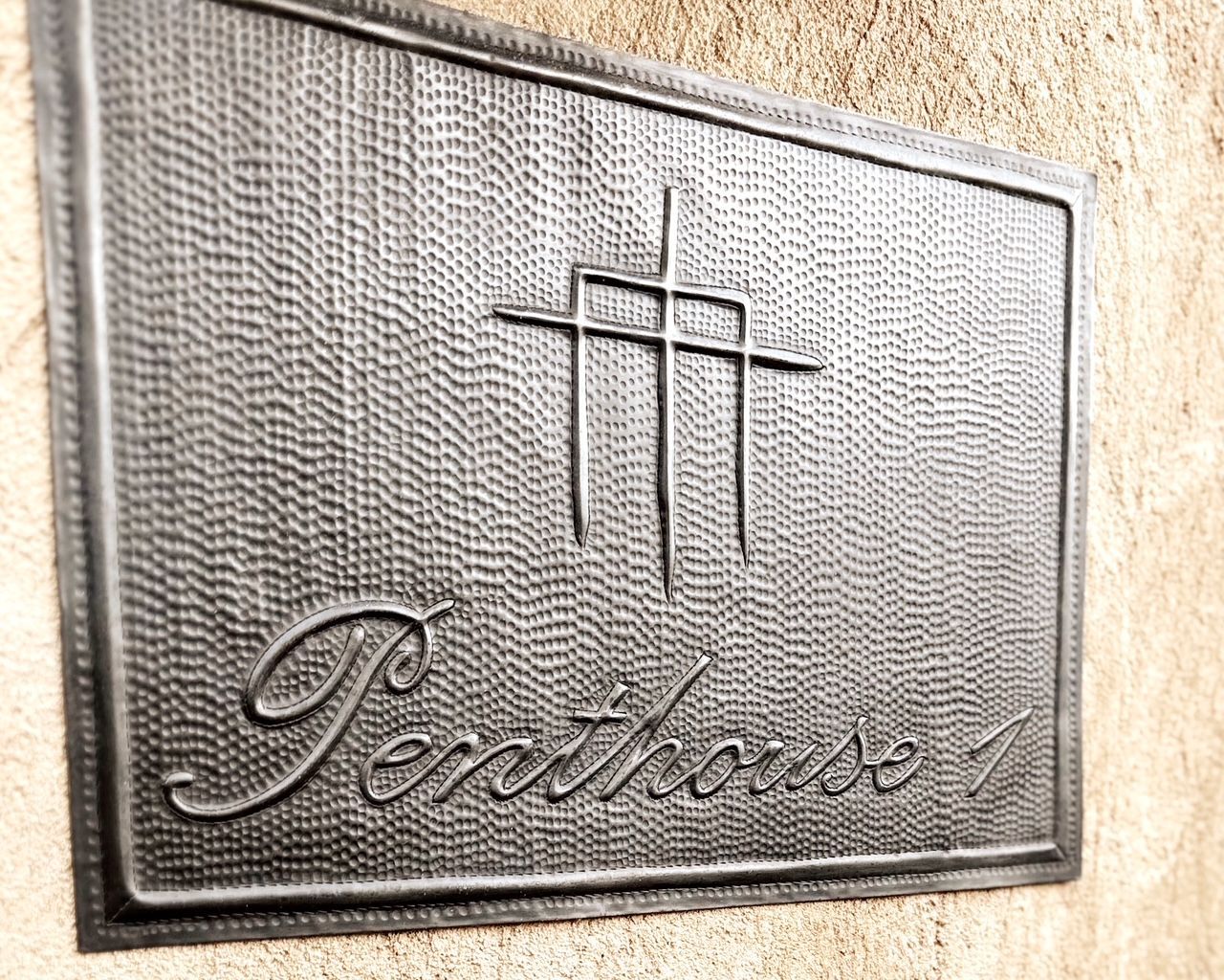 A metal sign on a wall that says penthouse.