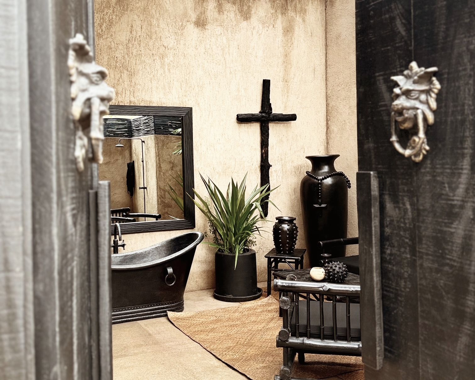 A bathroom with a black tub and a cross on the wall