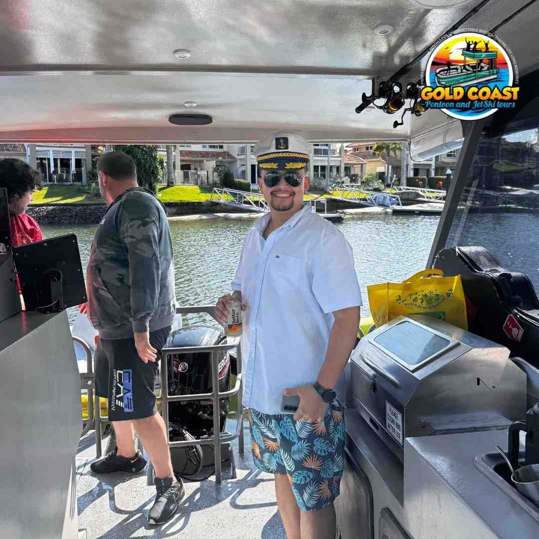 Man on a boat with a drink and hat, smiling. Gold Coast, Australia.