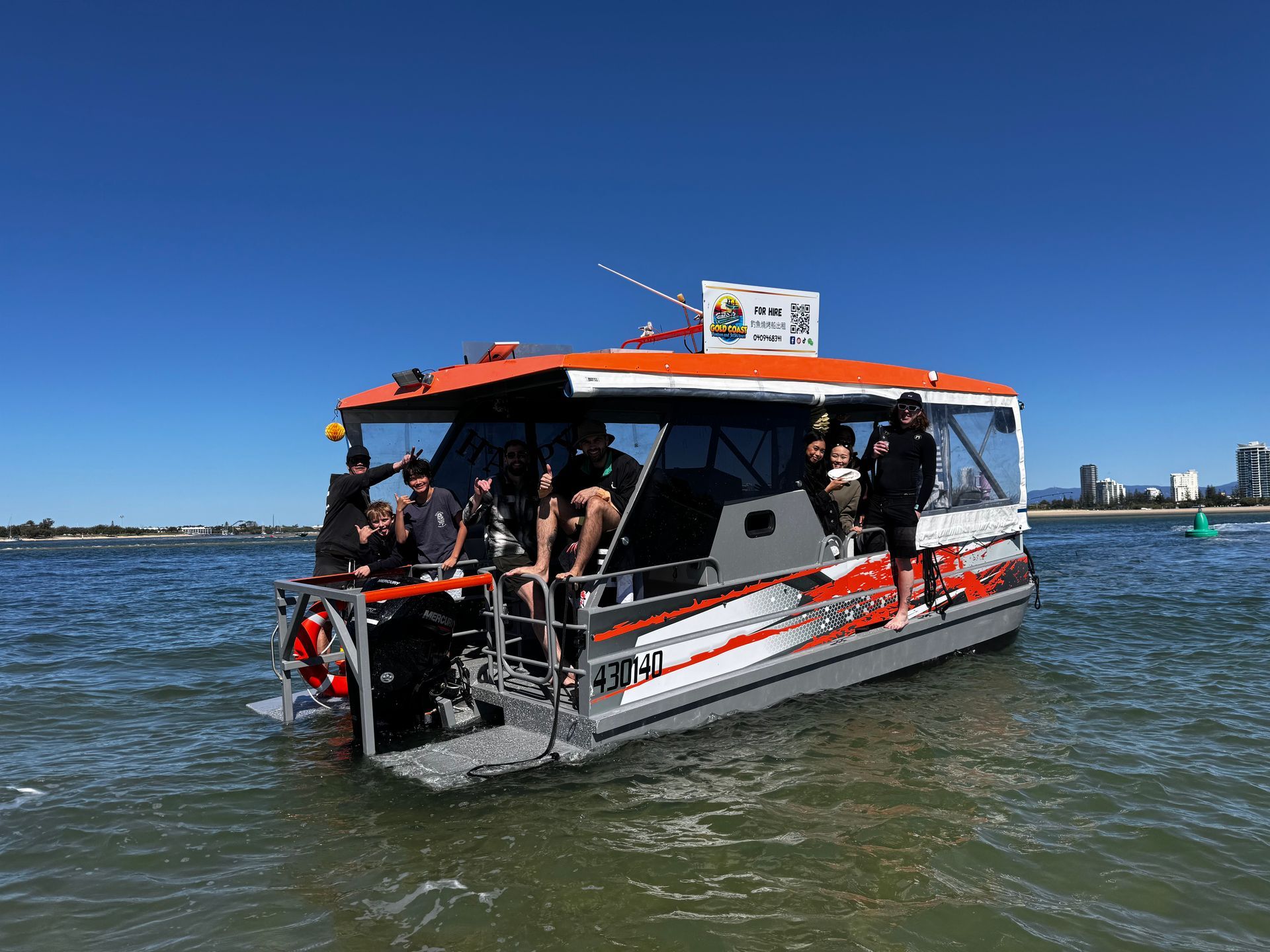 A boat with people on it is floating on top of a body of water.