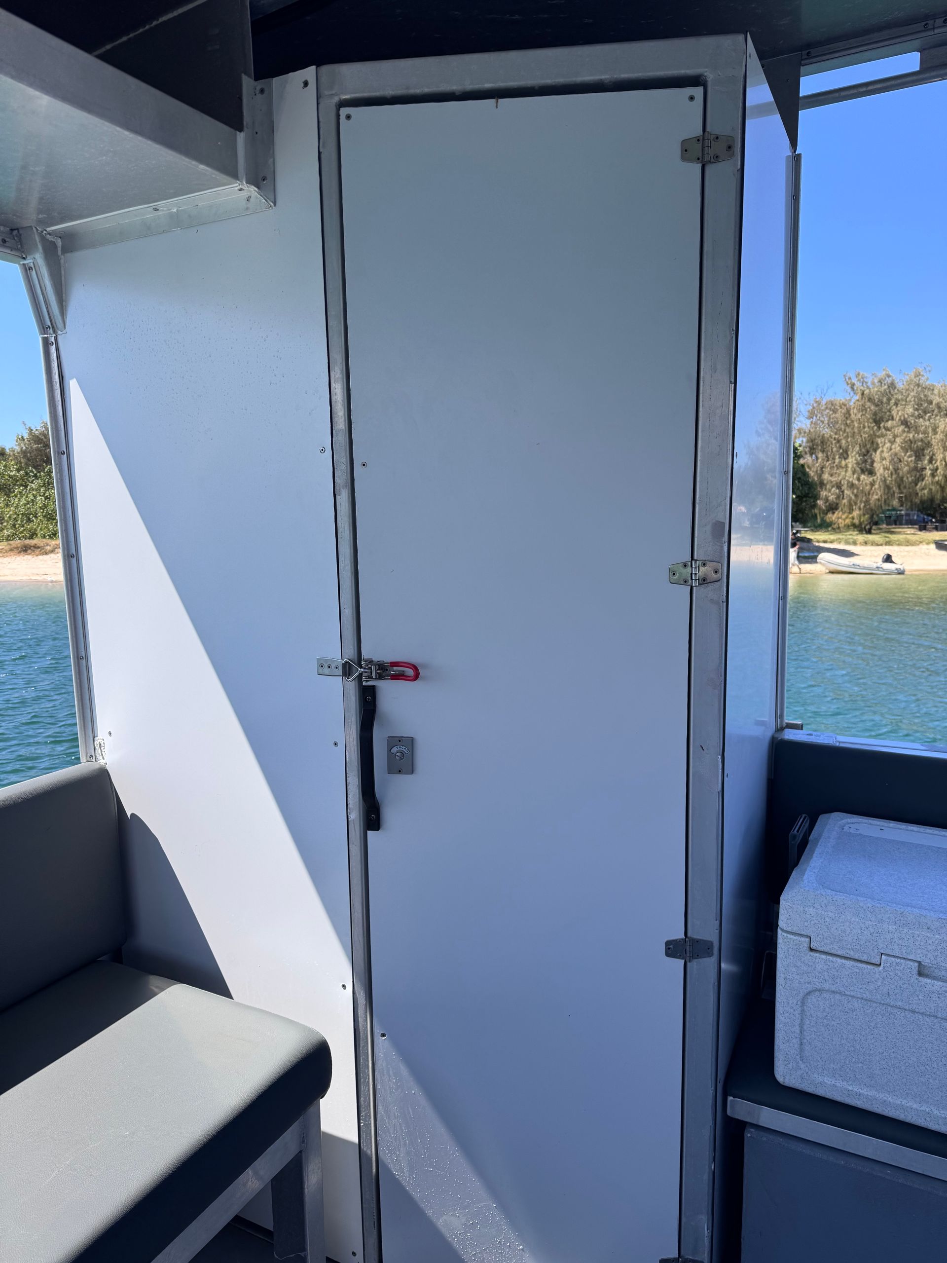 A boat with people on it is floating on top of a body of water.