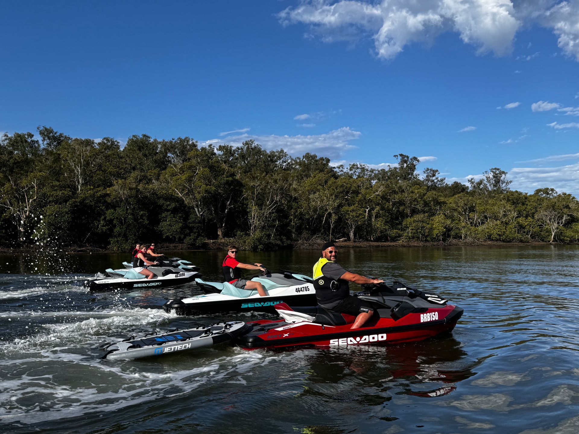 A group of people are riding jet skis on a lake.