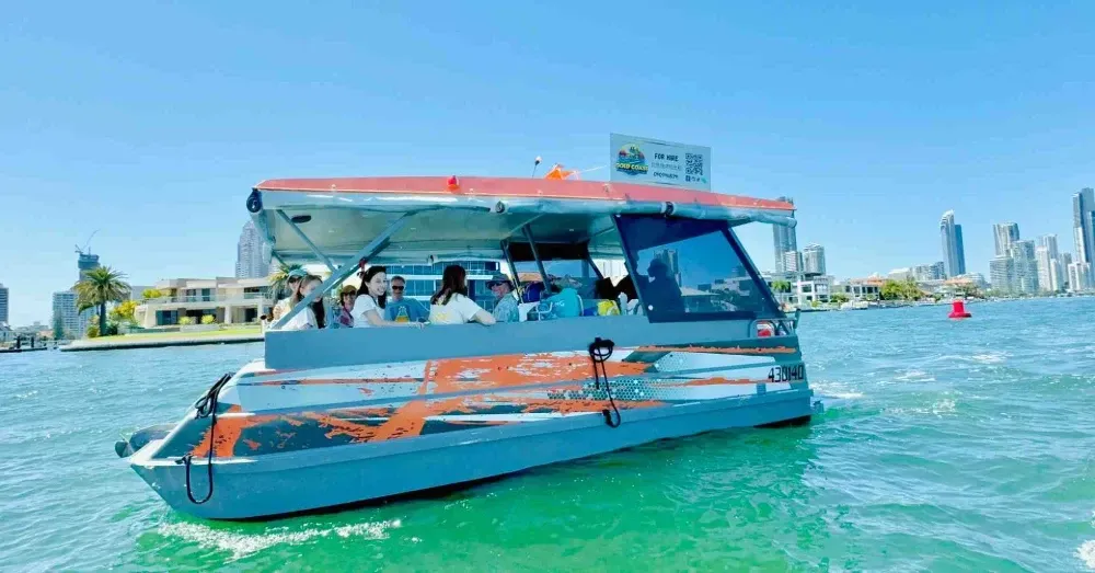 Group of people enjoying a sunny day on a BBQ pontoon boat cruising with the Gold Coast skyline in the background - Gold Coast BBQ boat
