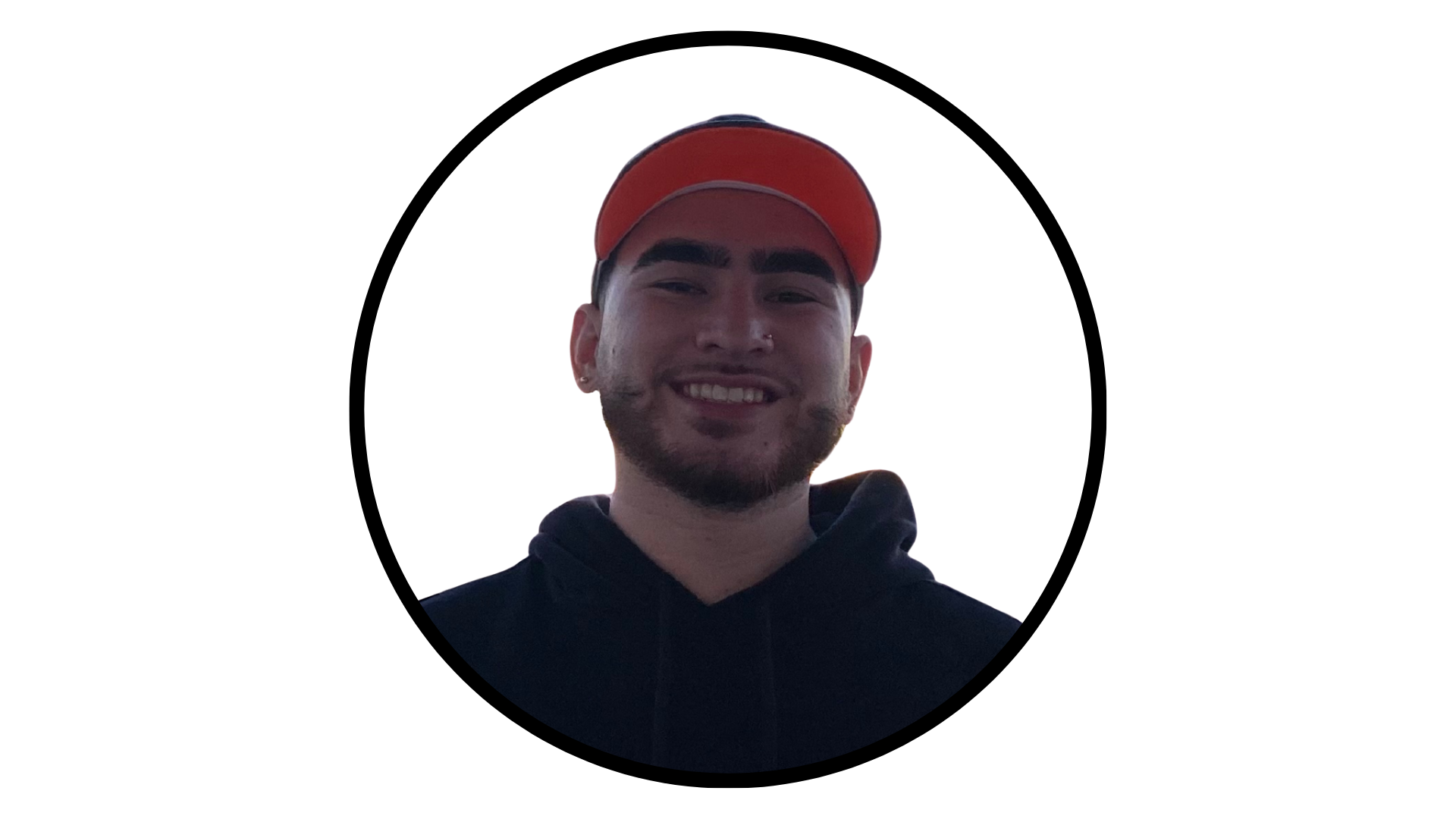 A person with a beard, wearing a black hoodie and a red baseball cap, on a white background.