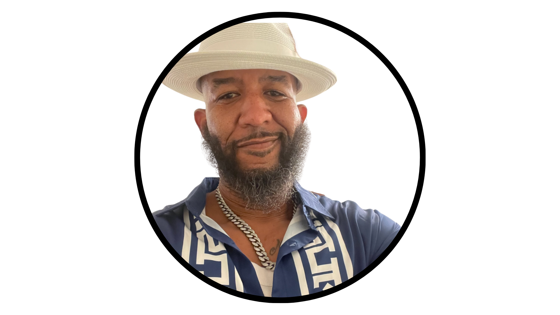 A person with a beard and hat wearing a blue, patterned short-sleeved shirt, centered in a circular frame.