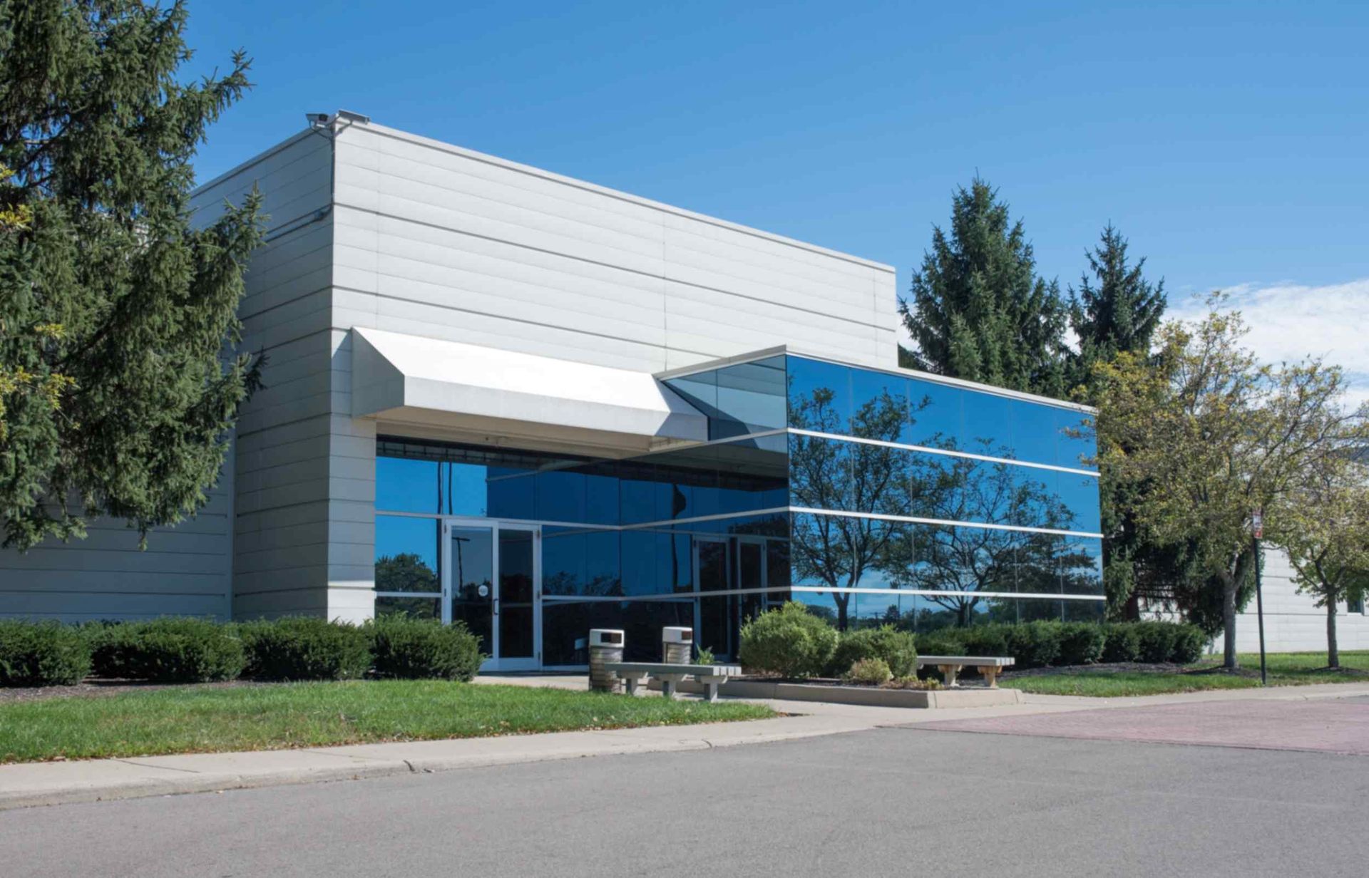 A Large Building With A Lot Of Windows And Trees In Front Of It  — Jay's Tint in Cairns, QLD