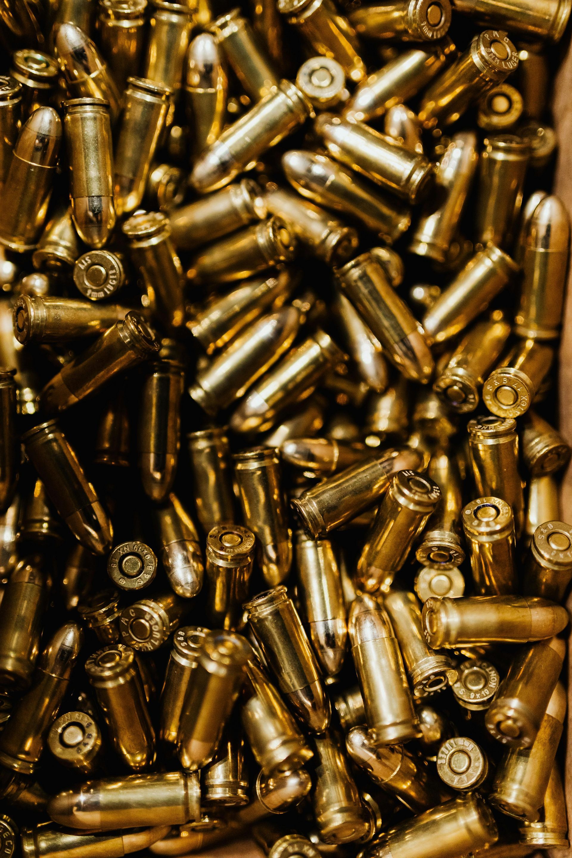 A pile of bullets in a box on a table.