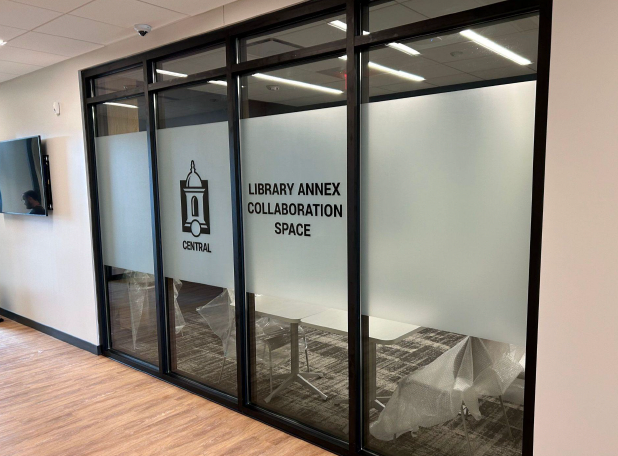 A glass door with a sign on it that says library annex collaboration space.