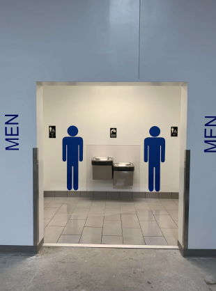 A men 's bathroom with two blue silhouettes on the wall