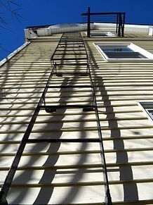 A fire escape ladder is attached to the side of a building.