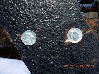 A close up of two bolts on a piece of metal.